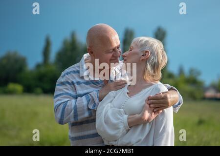 happy senior couple dating, hugging and kissing outdoor at sunset Stock Photo