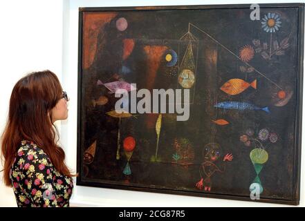 A fan of the German-Swiss Artist Paul Klee (1879-1940) studies his work titled Fish Magic, as she tours the Exhibition of his work at the Tate Modern Gallery, which is open to the public from 16th October until 9th March 2014, on the Southbank in central London. Stock Photo