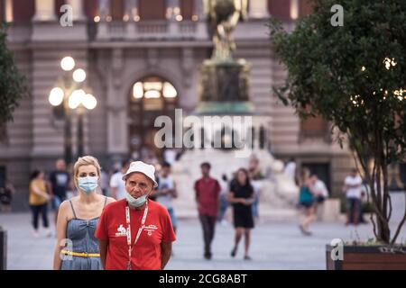 BELGRADE, SERBIA - AUGUST 26, 2020: Old senior man wearing a respiratory facemask under the chin while a young girl wears also a mask, correctly, duri Stock Photo