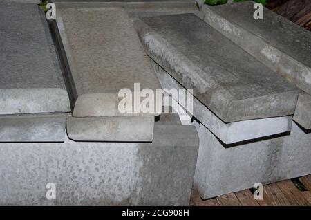 A stack of Gray Concrete road curbs is lying on a sidewalk before the reconstruction of the road. Stock Photo