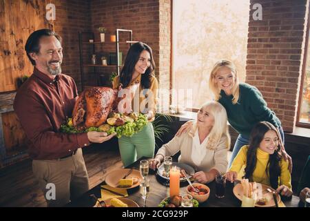 Portrait of nice attractive cheerful family meeting housekeeper carrying plate fresh homemade tasty yummy turkey reunion generation autumn at modern Stock Photo