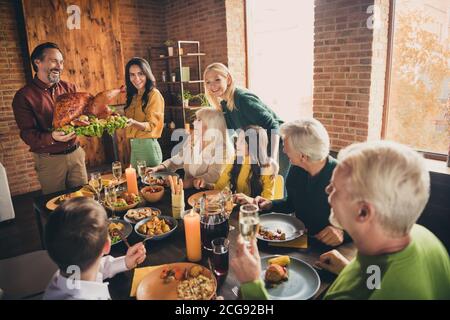 Portrait of nice attractive cheerful affectionate family gathering housekeeper carrying plate fresh homemade turkey serving table spending time at Stock Photo