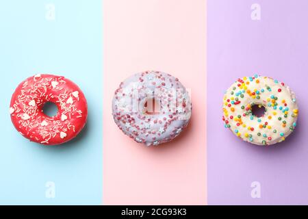 Tasty donuts on three tone background, top view Stock Photo