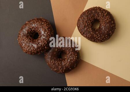 Tasty chocolate donuts on three tone background Stock Photo