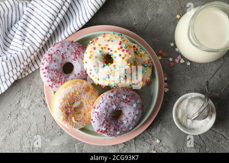 Concept of tasty food with donuts and milk on gray background Stock Photo