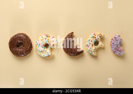 Tasty donuts on beige background, space for text Stock Photo