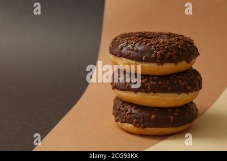 Tasty chocolate donuts on three tone background Stock Photo