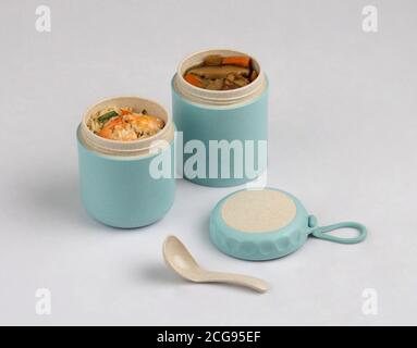 Opened tiffin box carrier with soup and shrimp fried rice isolated on white background Stock Photo