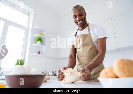 Portrait of his he nice attractive cheerful focused guy confectioner preparing fresh tasty yummy bread pizza pie pide doughing flour enjoying hobby in Stock Photo