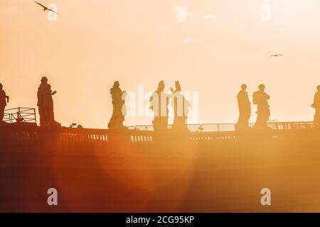 Sculptures of saints in Vatican, silhouette in sunset against sun flare Stock Photo