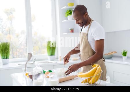 Portrait of his he nice attractive cheerful focused guy confectioner preparing bread pie georgian national cuisine mixing flour milk in modern light Stock Photo