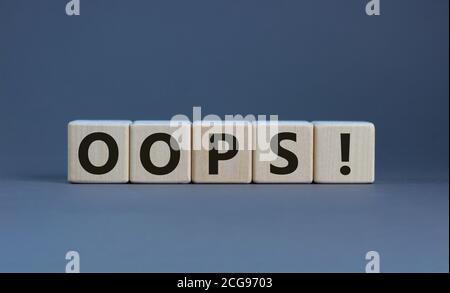 Oops sign on wooden cubes. Beautiful grey background, copy space. Concept. Stock Photo