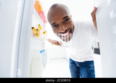 Close-up portrait of his he nice attractive cheerful cheery healthy guy looking in fridge finding fresh meal dish vitamin salad daily everyday health Stock Photo