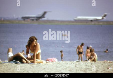 1970s - Constitution Beach - Within Sight and Sound of Logan Airport's Takeoff Runway 22r (pretty woman on beach 1970s) Stock Photo
