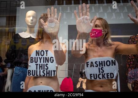 London, UK. 9th Sep 2020. Extinction Rebellion activist who glued themselves to the shop window of H&M in Oxford street in London looks at the members