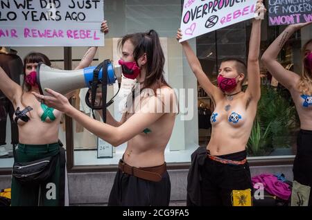 London, UK. 9th Sep 2020. Extinction Rebellion activist who glued themselves to the shop window of H&M in Oxford street in London looks at the members Stock Photo