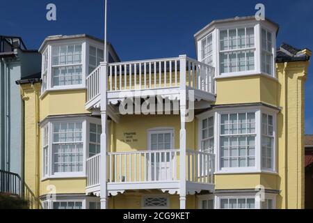 Aldeburgh, Suffolk, UK - 9 September 2020: Bright autumn day on the East Anglia coast. Yellow painted seafront house. Stock Photo