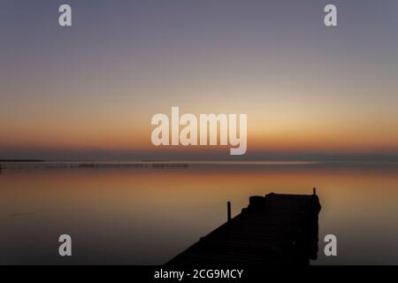Albufera in Valencia. Dock over the lake Called Albufera with the sun going down. Beutifull golden hour with the water calm Stock Photo