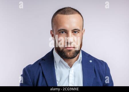 Positive young businessman dressed formally in blue stylish suit, having a decisive attitude to conclude a profitable deal, isolated over white backgr Stock Photo