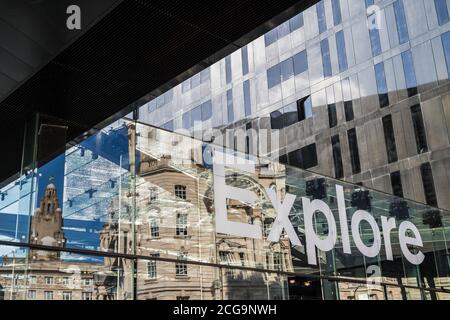 Reflections of the Three Graces on the Liverpool waterfront seen reflecting behind glass with the word explore.  Captured in September 2020. Stock Photo