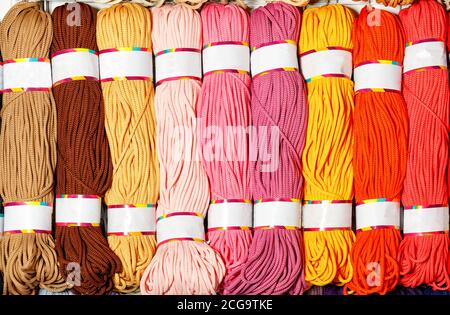 Skeins of polyester cord in various bright colors of hot shades, rolled into rolls, close-up, copy space. Stock Photo