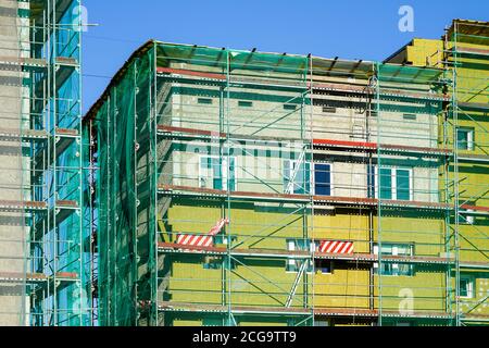 scaffolding arround the house to install thermal insulation of the apartment building facade Stock Photo