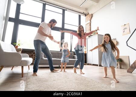 happy family mother father and child daughter dancing at home. Stock Photo