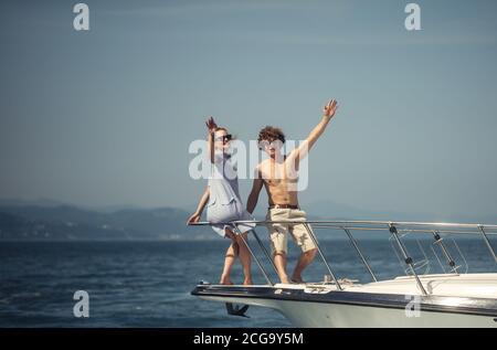 Caucasian couple standing on the front of a sail boat sailing on a calm blue sea. Beautiful seascape with copy space. Stock Photo