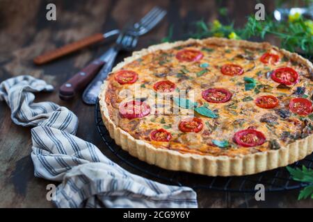 Delicious homemade quiche lorraine with chicken, tomato, mushrooms and cheese Stock Photo