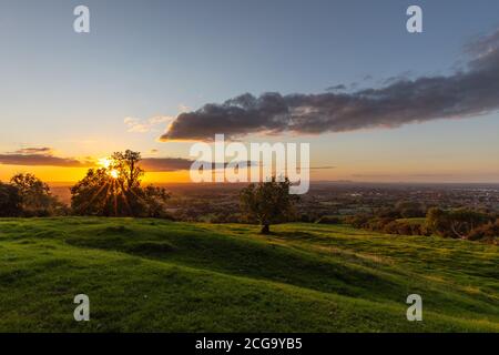 The Sun Setting  .View From Lechampton Hill On The Road Going Into The Local Spa Town In The Cotswolds  Called Cheltenham In Gloucestershire England.