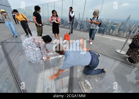 New York City, USA. 09th Sep, 2020. People take turns sitting on the glass floor at Edge, the new observation deck on the 100th floor of 30 Hudson Yards, New York, NY, on September 9, 2020. Offering panoramic views of New York City and New Jersey from 1,131 feet high, recently reopened Edge is the highest outdoor sky deck in the Western Hemisphere. (Anthony Behar/Sipa USA) Credit: Sipa USA/Alamy Live News Stock Photo