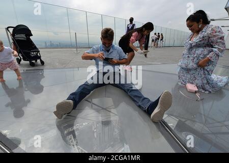 New York City, USA. 09th Sep, 2020. People take turns sitting on the glass floor at Edge, the new observation deck on the 100th floor of 30 Hudson Yards, New York, NY, on September 9, 2020. Offering panoramic views of New York City and New Jersey from 1,131 feet high, recently reopened Edge is the highest outdoor sky deck in the Western Hemisphere. (Anthony Behar/Sipa USA) Credit: Sipa USA/Alamy Live News Stock Photo