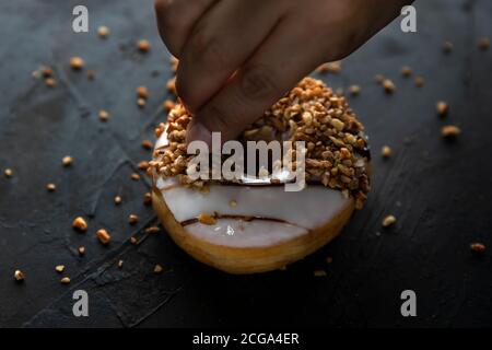 Doughnut covered with chopped nut dark food Photography Stock Photo