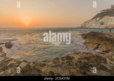 Rosh HaNikra, Israel - September 07, 2020: View of the sunset with the coast and cliffs of Rosh HaNikra, with visitors, Northern Israel Stock Photo