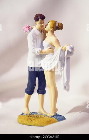 A mould of two figures of a couple holding each other from a wedding cake topping Stock Photo