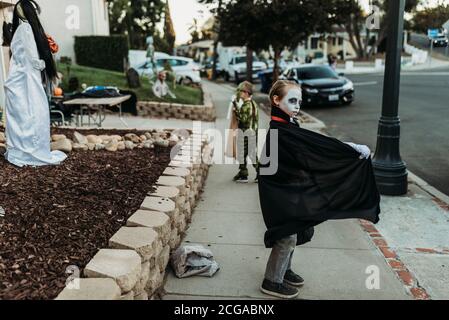 School aged boy dressed as Dracula Trick-or-Treating during Halloween Stock Photo