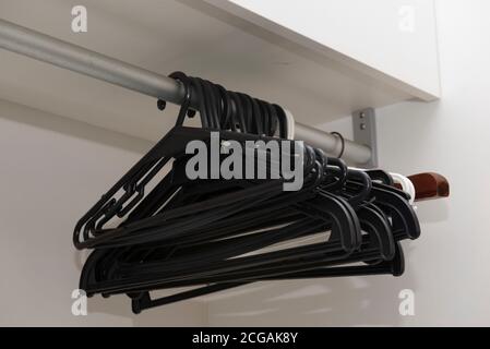 Group of empty hangers hanging from a stainless rod. Empty closet concept with no clothes. Stock Photo