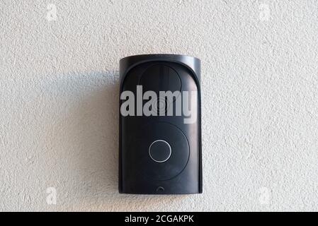 Black intercom without camera on rough beige wall. Communication system for home protection. Stock Photo