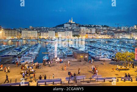 evening view of Vieux Port, the Old Port of Marseille with Basilique Notre-Dame de la Garde in the background on the highest natural point in Marseill Stock Photo