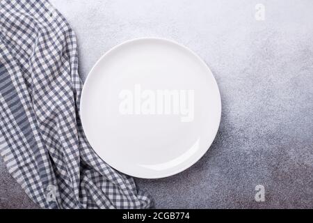 Empty white plate and linen napkin on stone background Copy space Top view - Image Stock Photo