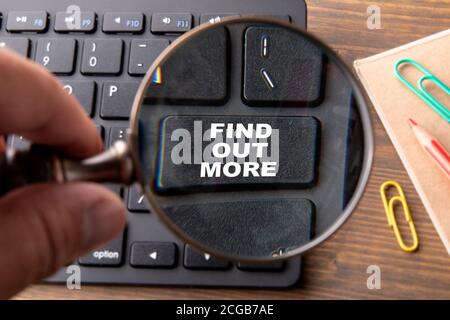 FIND OUT MORE. Computer keyboard on a wooden table. Stock Photo