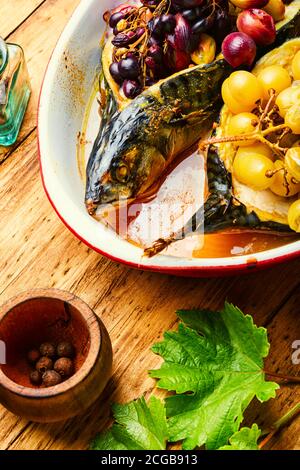 Baked mackerel or scomber in berry sauce on wooden table Stock Photo
