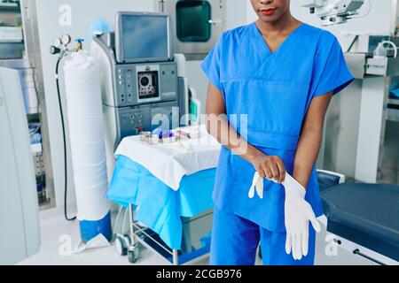 Nurse putting on rubber gloves Stock Photo