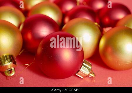 Lots of red and gold Christmas balls on a red background close up Stock Photo