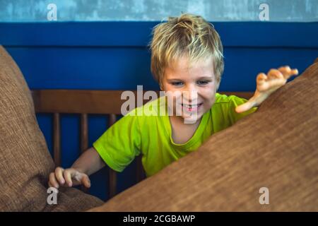 Portrait mischievous cute blond blue eyed boy making freckles face play laughing in happy mood. Funny photo, happiness lifestyle. Daycare, simple joys Stock Photo