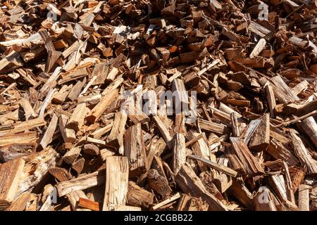A background image of a pile of wooden logs cut into different shapes and sizes and scattered irregularly. This close up image is a suitable wallpaper Stock Photo