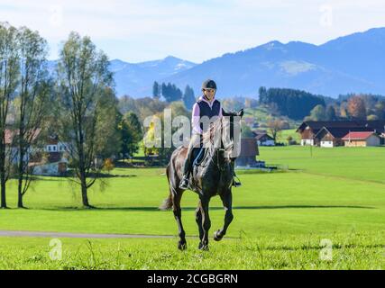 Woman riding out in falltime morning in bavarian Allgäu Stock Photo