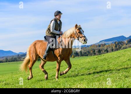 Woman riding out in falltime morning in bavarian Allgäu Stock Photo