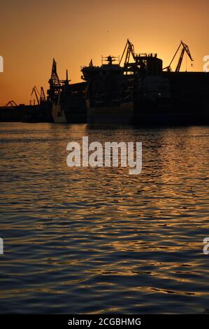 Harbor and Cranes against red sunset background in summer Stock Photo