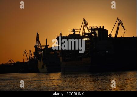 Harbor and Cranes against red sunset background in summer Stock Photo